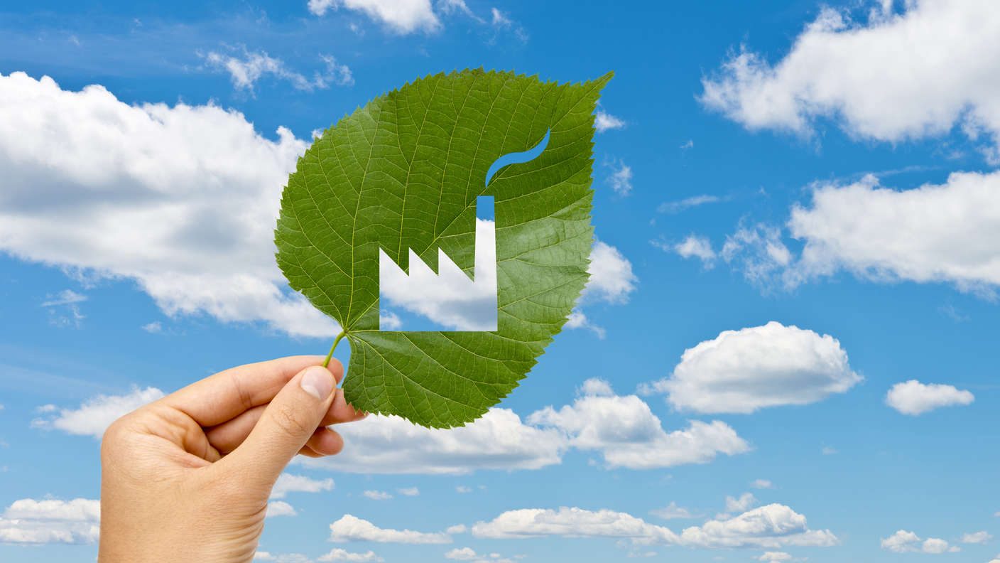 Ein Blatt mit einer Firma ausgeschnitten, die in den Himmel gehalten wird.