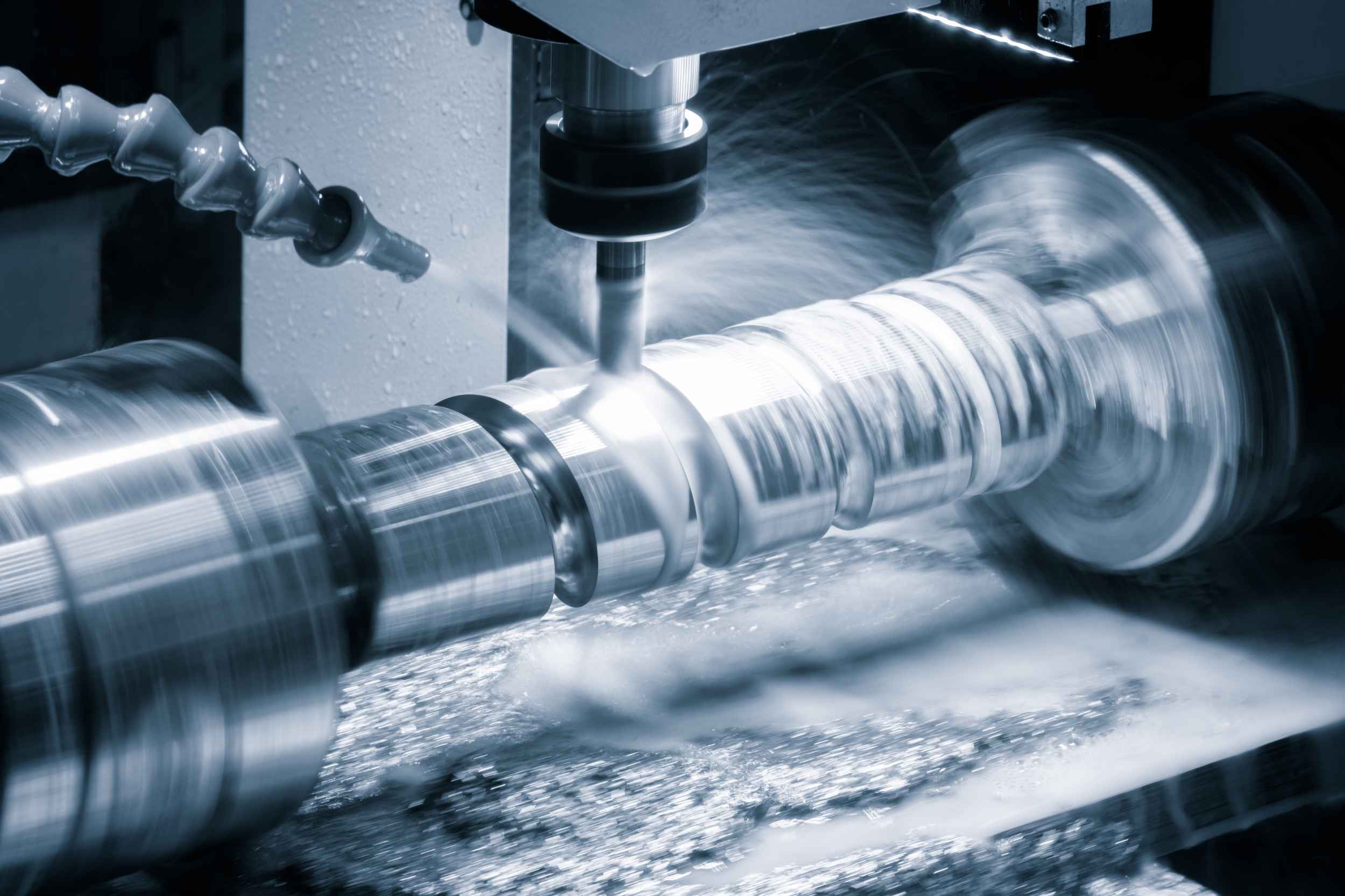Fräsvorgang an einem rotierenden Metallzylinder mit CNC-Maschine und Kühlmittelschmierung