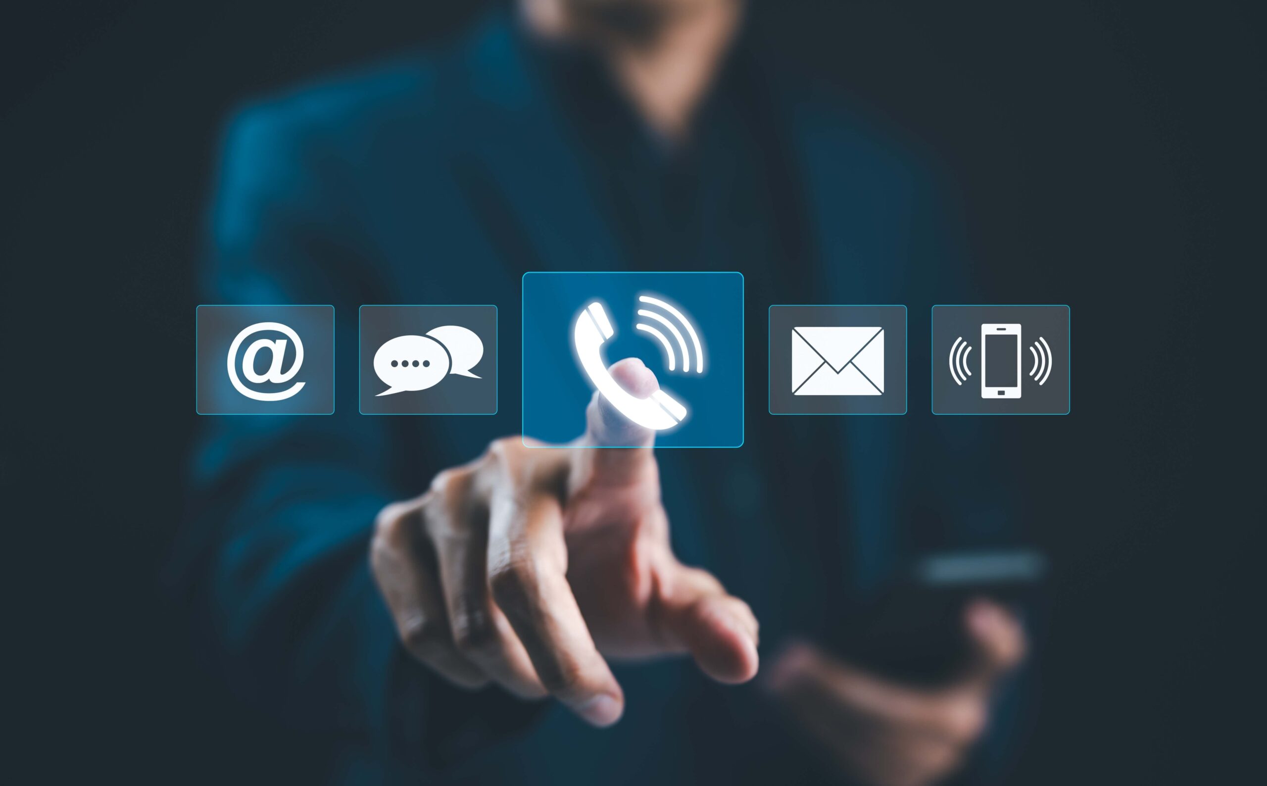 Hand tippt auf Telefonhörer-Symbol in einer Reihe von Kommunikationssymbolen wie E-Mail, Chat und Smartphone